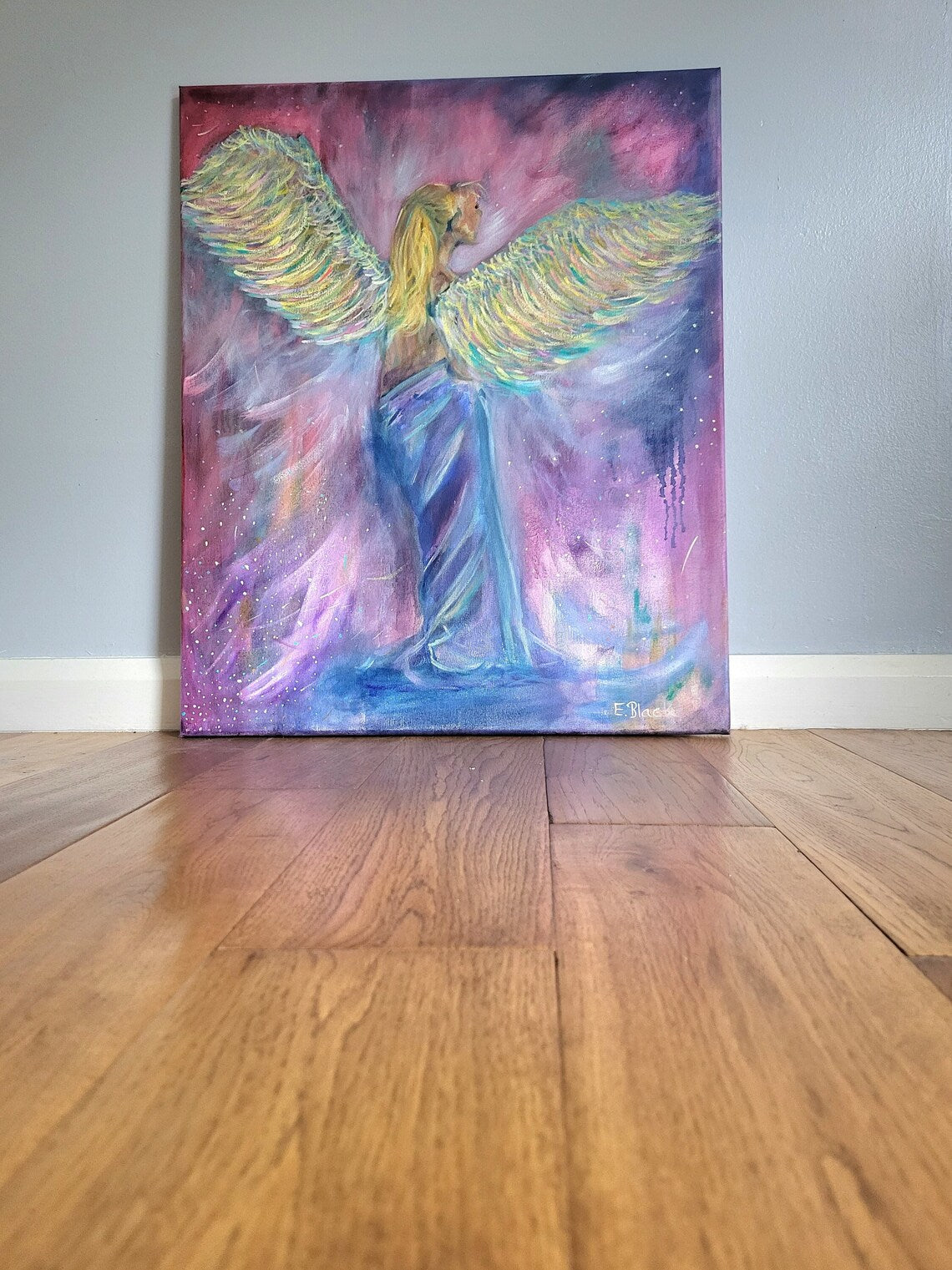 Original oil painting of a topless angel wearing blue robes and multicoloured wings.
