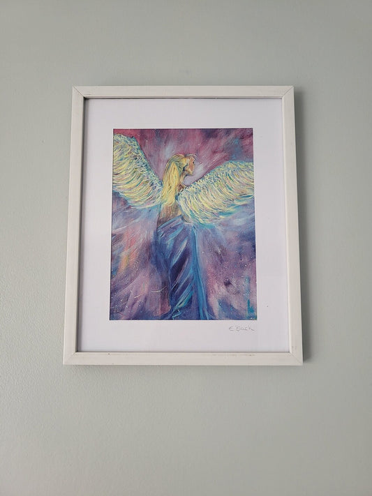 An A5 giclee fine art print of an angel painting, with a visible frame, hanging on a wall.