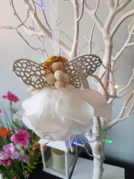 Decorative winter angel figure with silver wings on a white christmas tree.